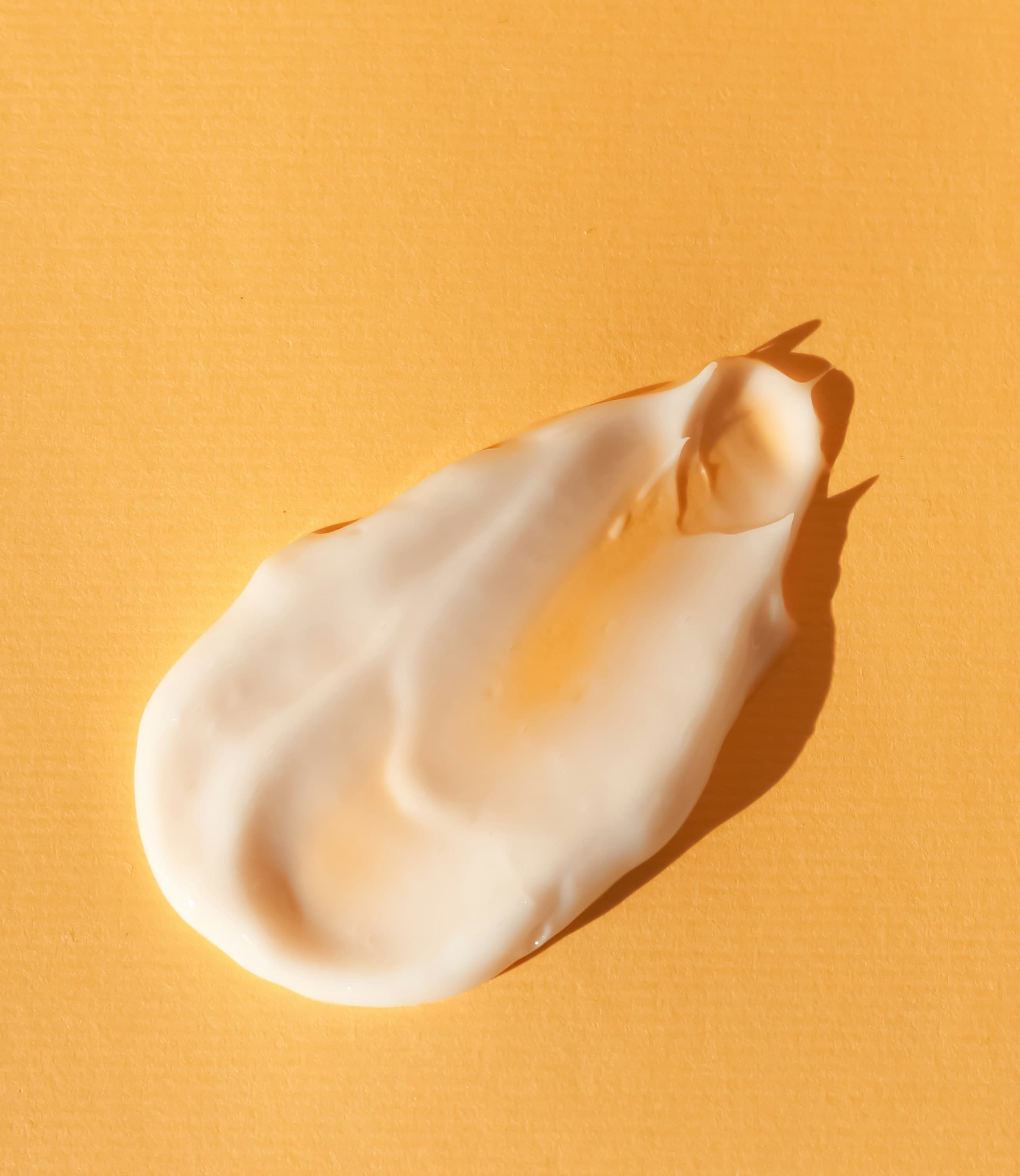 Close-up of a white cosmetic texture on a warm surface