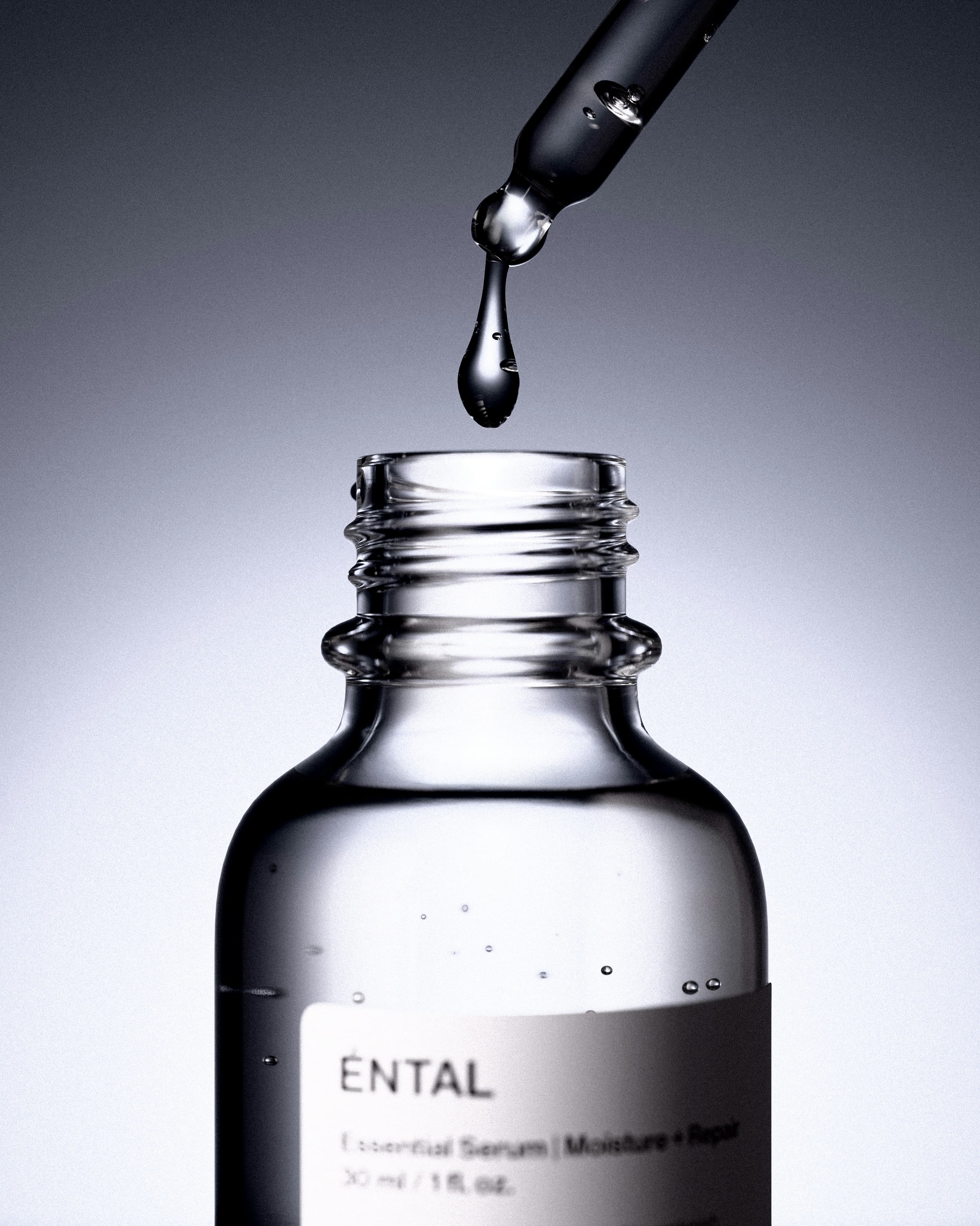 A dropper releasing serum into a bottle
